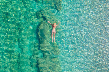 Top view. Young beautiful naked woman in a hat swimming in sea water on sand beach. Drone, copter photo. Summer vacation. View from above. - 483338197