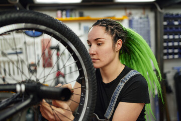 Fototapeta na wymiar Mechanic fixing bike wheel in service