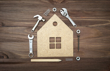 Hand tools and fasteners arranged around a house shape
