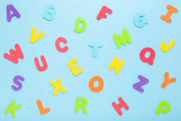 Colorful letters on light blue table. Pattern background. Pastel color. Time to learning English alphabet. Closeup. Top down view.