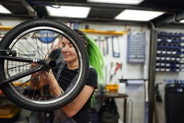 Content woman repairing bicycle wheel