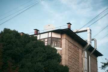 a panel house, blue sky and green trees on a sunny summer day post-soviet