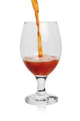 Dark amber beer is poured into a glass in a stream. Isolated on a white background with reflection