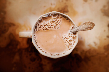 Top view of a gray mug of warm cocoa with milk and a beautiful teaspoon. Nice breakfast. Food...