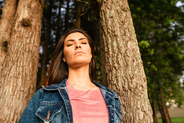 beautiful woman meditating with eyes closed in the woods