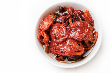 Sun dried tomatoes  on white bowl, white wooden background. Dried tomatoes  recipe.  Top view,  copyspace.