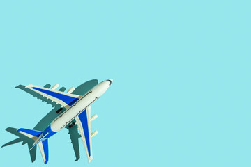 Passenger plane toy on blue background with copy space. Travel concept.