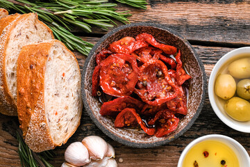 Italian ingredients  food background. Slices of ciabatta bread  on wooden board with olives, dried...