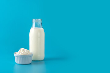 Milk kefir drink on wooden table. Liquid and fermented milk product on blue background. Copy space - obrazy, fototapety, plakaty