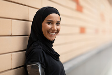 Portrait Of Smiling Young Muslim Lady In Hijab Posing During Training Outdoors