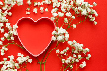 Valentine's heart with gypsophila flowers on a red background. Copy space.