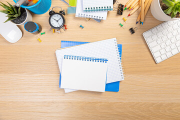 Working table with keyboard and notepad, pen, pencil and plant in home office. top view