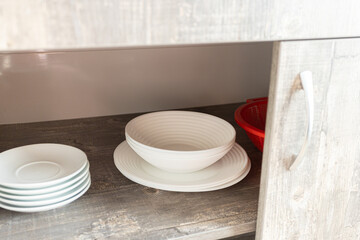 open cabinet door with stacked plates at home