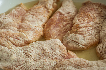 frying raw chicken breast fillet flour covered closeup