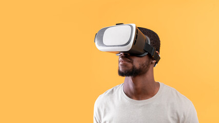 Modern technologies for entertainment. Young black guy wearing vr glasses, experiencing virtual reality, free space