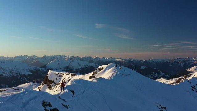 Young man climbing on ski in Alps. Aerial footage of winter activity. Alpin hiking, beautiful snowy mountain peaks.