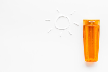 Sunscreen in bottles flatlay with sun made of white cream