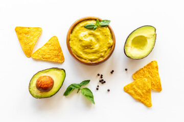Avocado guacamole sause in bowl with nachos chips