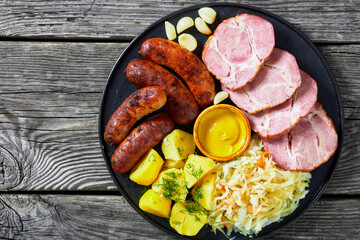 bratwurst, pork, potatoes, sauerkraut on a plate
