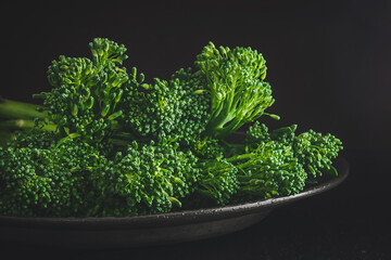 Fresh bimi vegetable on a dark table. Raw baby broccoli