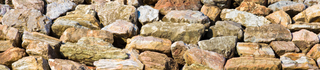 Wall made of rocks and boulders of natural stone - embankment concept