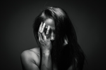 Depression or domestic violence concept: Unhappy young woman hiding her face with one hand. Sadness...