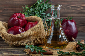 Apple cider vinegar and red apples on a dark, wooden background. Selective focus. fermented product. Healthy food.