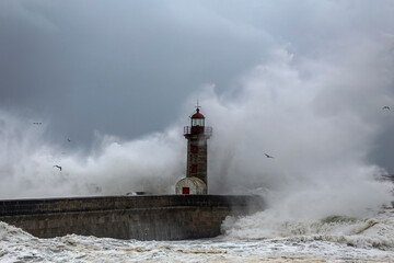 Fototapeta na wymiar Spray from big breaking waves over lighthouse