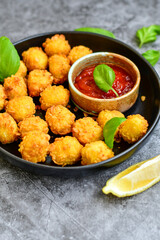 Crispy  deep fried   chicken  popcorn  nuggets . Breaded  with Cornflakes chicken  Breast fillets  with chilly peppers and fresh   basil on wooden rustic background