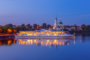Obraz premium Cruise ship on Volga river against St. Catherine monastery in summer evening. Beautiful night Russian cityscape with cruise liner on water. Travel blog concept. Tver, Russia