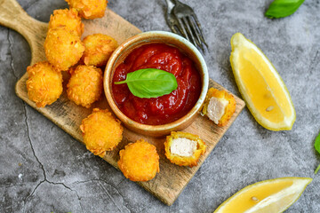 Crispy  deep fried   chicken  popcorn  nuggets . Breaded  with Cornflakes chicken  Breast fillets  with chilly peppers and fresh   basil on wooden rustic background