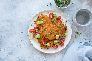 vegan herb sweet potato fritters served with vegetable salad and green sprouts. Plant based diet concept. copy space