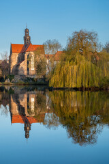 Fototapeta premium Monastery behind pond is reflected in the water. Marienrode Monastery