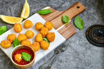 Fototapeta na wymiar Crispy deep fried chicken nuggets . Breaded with Cornflakes Breast fillets with chilly peppers and fresh basil on wooden rustic background