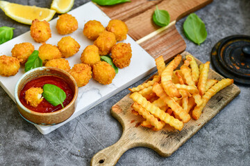 Crispy  deep fried   chicken  popcorn  nuggets and french fries . Breaded  with Cornflakes chicken  Breast fillets  with chilly peppers and fresh   basil on wooden rustic background