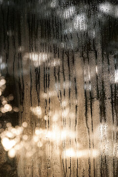 Rain dripping down a window but sun flares shining through