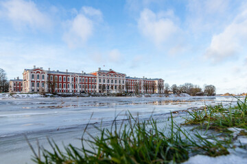 Fototapeta na wymiar Low angle view to the Latvia University of Life Sciences and Technologies at frozen riverbank in Jelgava, Latvia. Residence for the Dukes of Courland in their capital of Mitau.