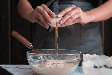 Confectioner breaks the egg and add to the bowl.