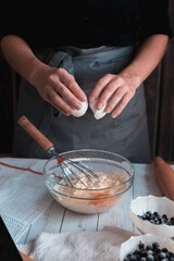 Confectioner breaks the egg and add to the bowl.