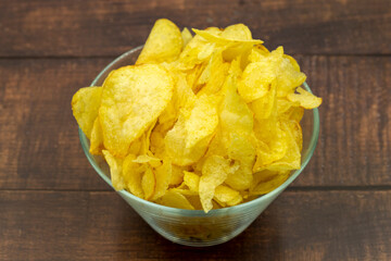 Potato chips or Crispy in a bowl on a wooden background. Close up