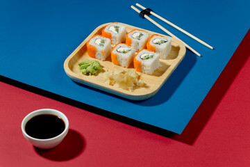 Sushi on a plate on a bright, colored background. 