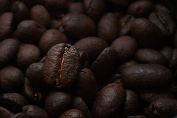 Naklejka premium Macrophotography of coffee beans. Coffee close-up. Advertising backdrop for coffee shop or restaurant. Aromatic roasted coffee of fresh harvest.