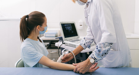 Doctor doing the ultrasound on the hand close up. Doctor demonstrates results of ultrasound to...