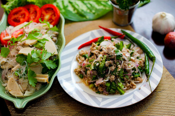 Spicy vietnamese sausages salad and Spicy minced pork.(Thai food) With onion, garlic, red pepper on a black wooden table
