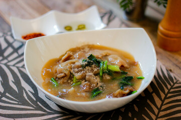 Wide Rice Noodles with pork in Gravy Sauce in white Plate or what we call 