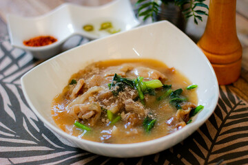 Wide Rice Noodles with pork in Gravy Sauce in white Plate or what we call 