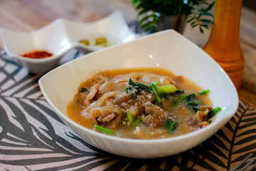 Wide Rice Noodles with pork in Gravy Sauce in white Plate or what we call 