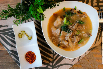 Wide Rice Noodles with pork in Gravy Sauce in white Plate or what we call 