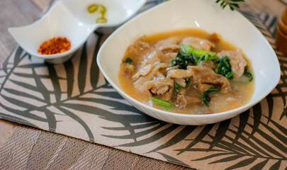 Wide Rice Noodles with pork in Gravy Sauce in white Plate or what we call 