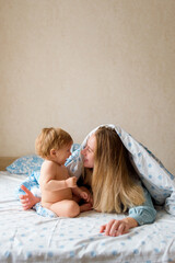 Mother playing with Lovely Baby in Bed in the morning